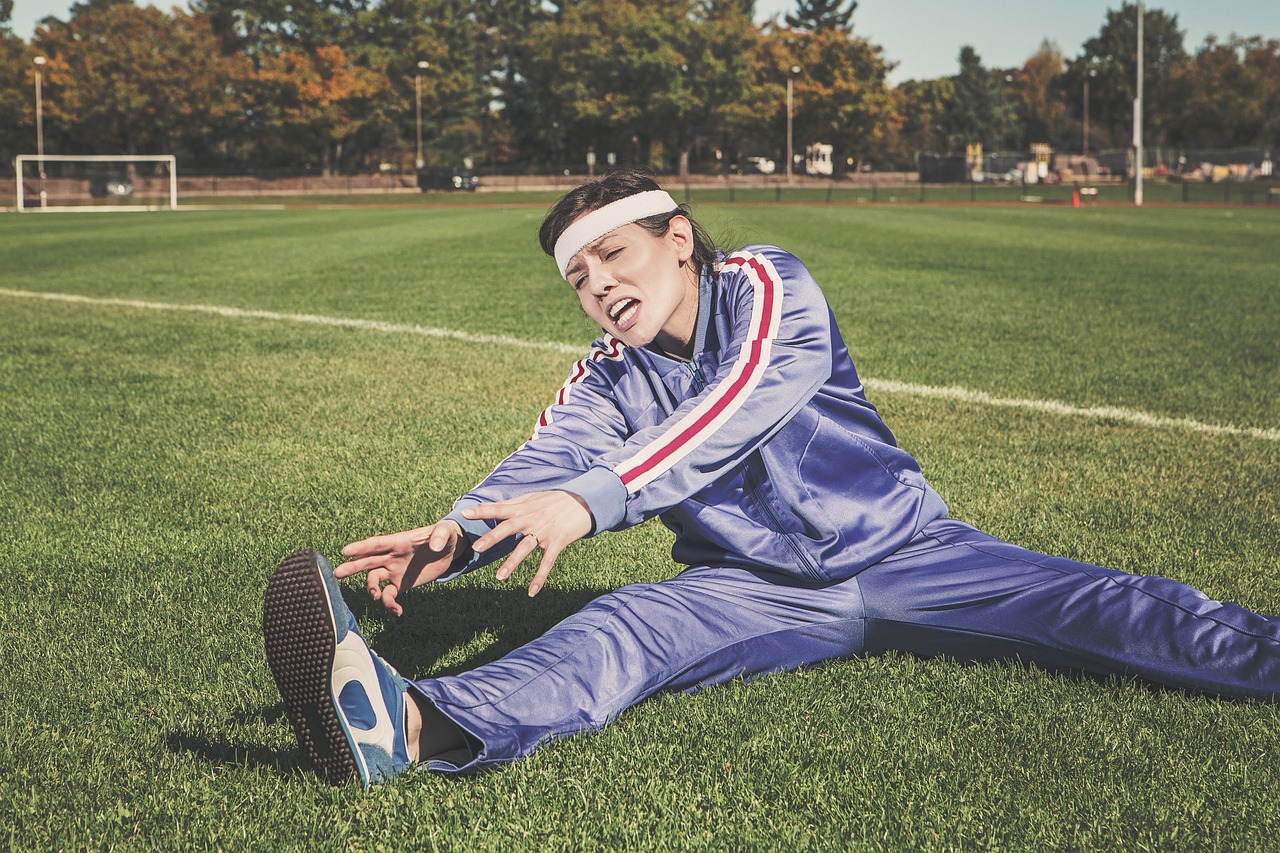 a woman stretching in a field to achieve her fitness vision